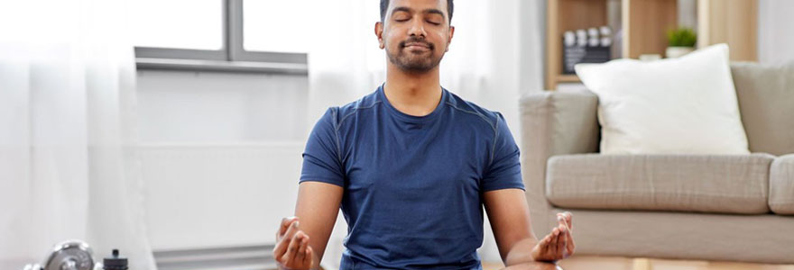 Homme pratiquant la méditation dans son salon